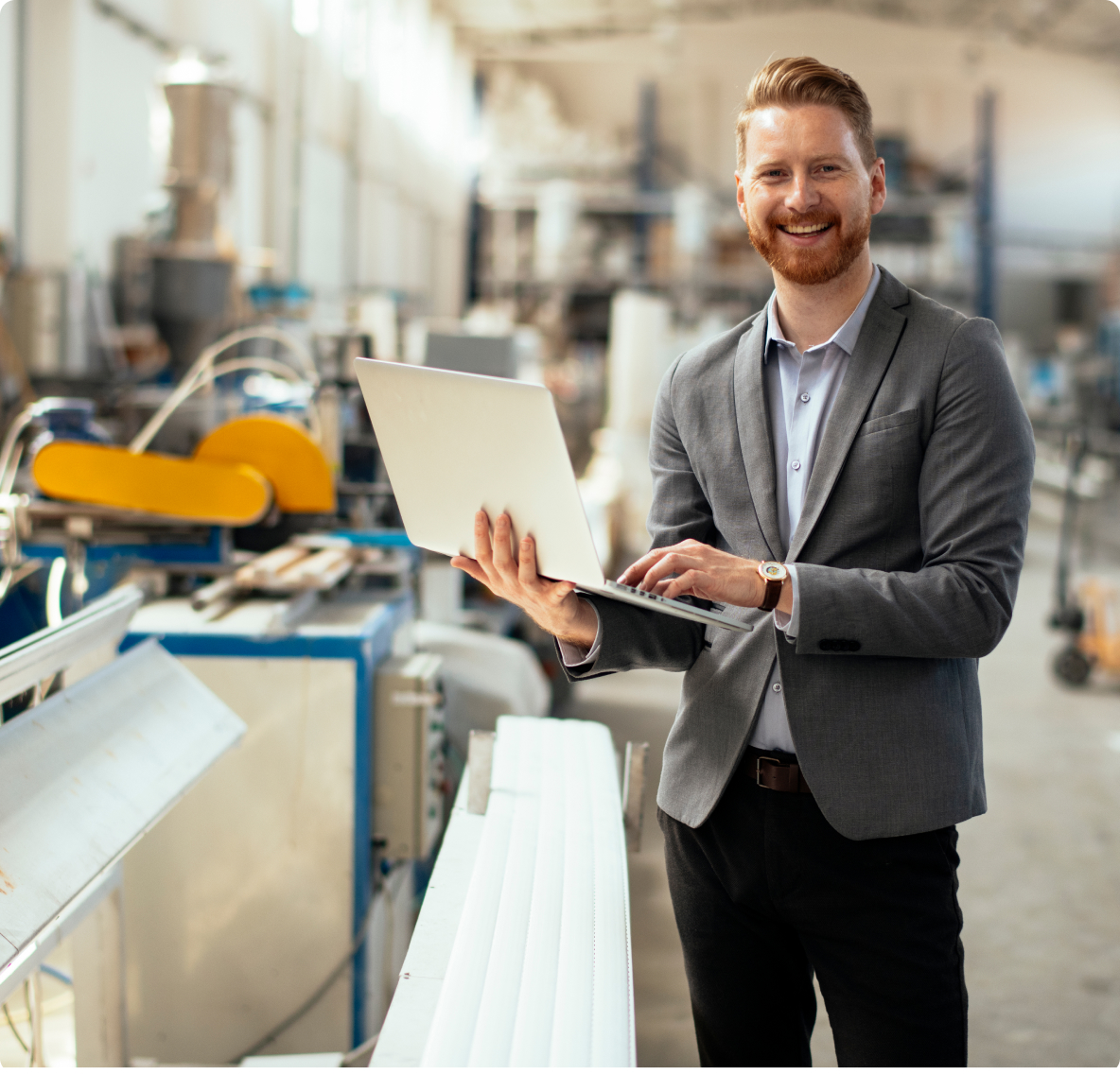 Engineering standing in the factory and working with a productivity platform on his computer