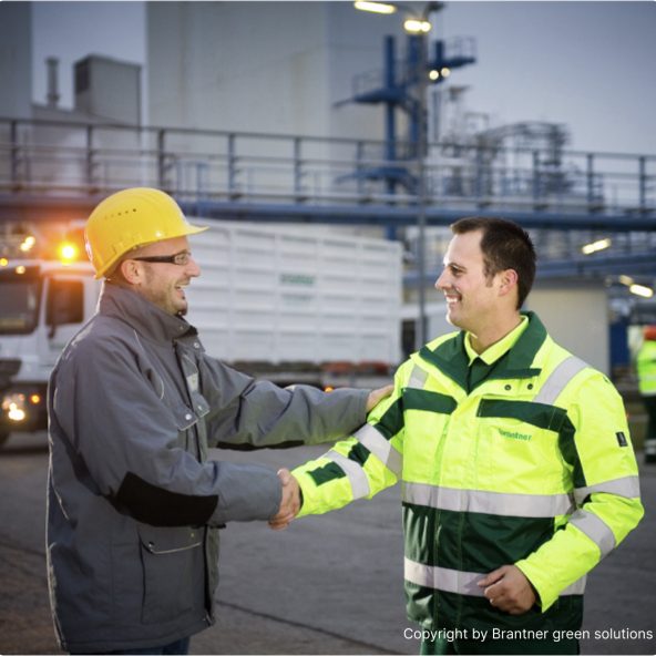 Two men standing and shaking hands at Brantner green solutions facilities
